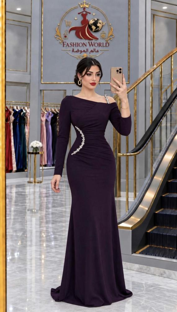 فستان باربي ناعم طويل بلون عنابي و ليلكي بتصميم "ون شولدر" (قَصّة كتف واحد) مع كم طويل، ويزينه تفصيل مرصع بالكريستال اللامعة على الخصر والكتف