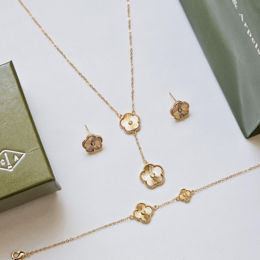 A Van Cleef jewelry set of necklace, bracelet, and earrings in gold with accessories