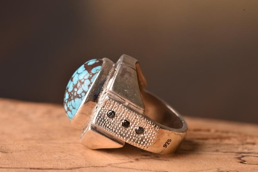 خاتم فضة بصياغة سعيد (أنتيك) عيار ٩٢٥، يتألق بحجر الفيروز السيناوي (المصري) بخيوط شبكية وستة فصوص زركون. المقاس: 22 الوزن: 28.5 جرامًا أبعاد الحجر: 16*12 ملم