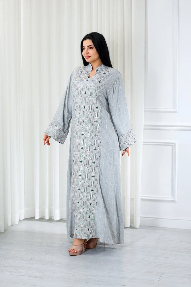 A long, ankle-length fabric jalabiya with a small collar and front embroidery on the sleeve cuffs, decorated with sparkling sequins.