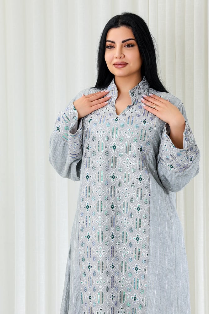A long, ankle-length fabric jalabiya with a small collar and front embroidery on the sleeve cuffs, decorated with sparkling sequins.