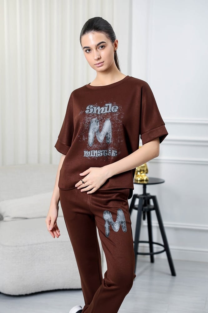 Women's casual tracksuit: T-shirt with elbow-length sleeves featuring a large print on the chest in gray, and pants with a wide, gathered waist.