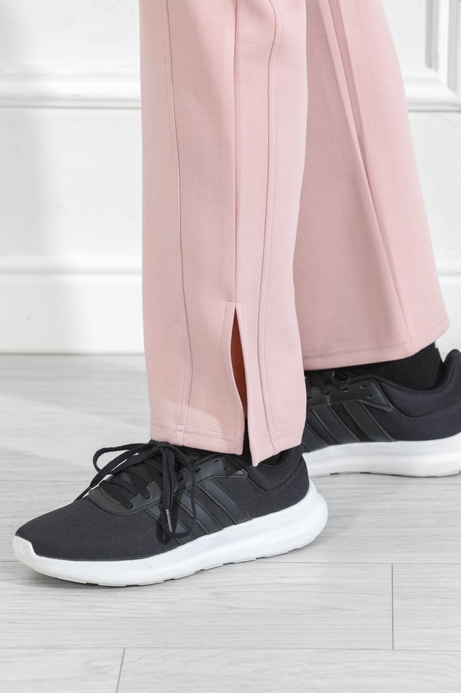 Women's casual medical tracksuit with mid-length sleeves, featuring a medium-sized letter print on the t-shirt and plain pants with a pocket and a side slit at the bottom of the pants.