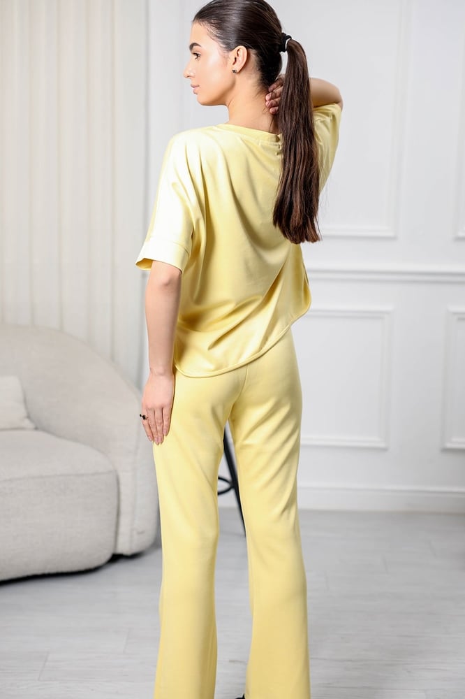 Women's casual tracksuit: T-shirt with elbow-length sleeves featuring a large print on the chest in gray, and pants with a wide, gathered waist.