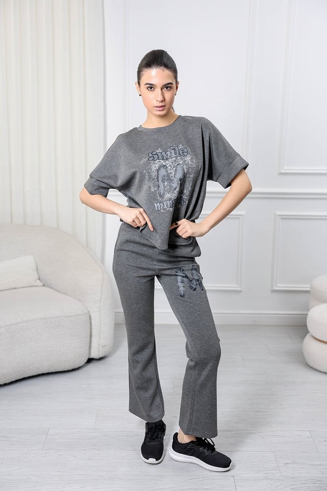 Women's casual tracksuit: T-shirt with elbow-length sleeves featuring a large print on the chest in gray, and pants with a wide, gathered waist.