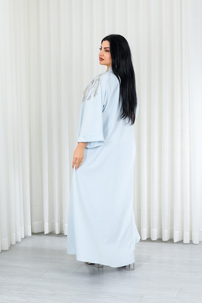 A long, ankle-length fabric jalabiya decorated with vertical embroidery on the chest.
