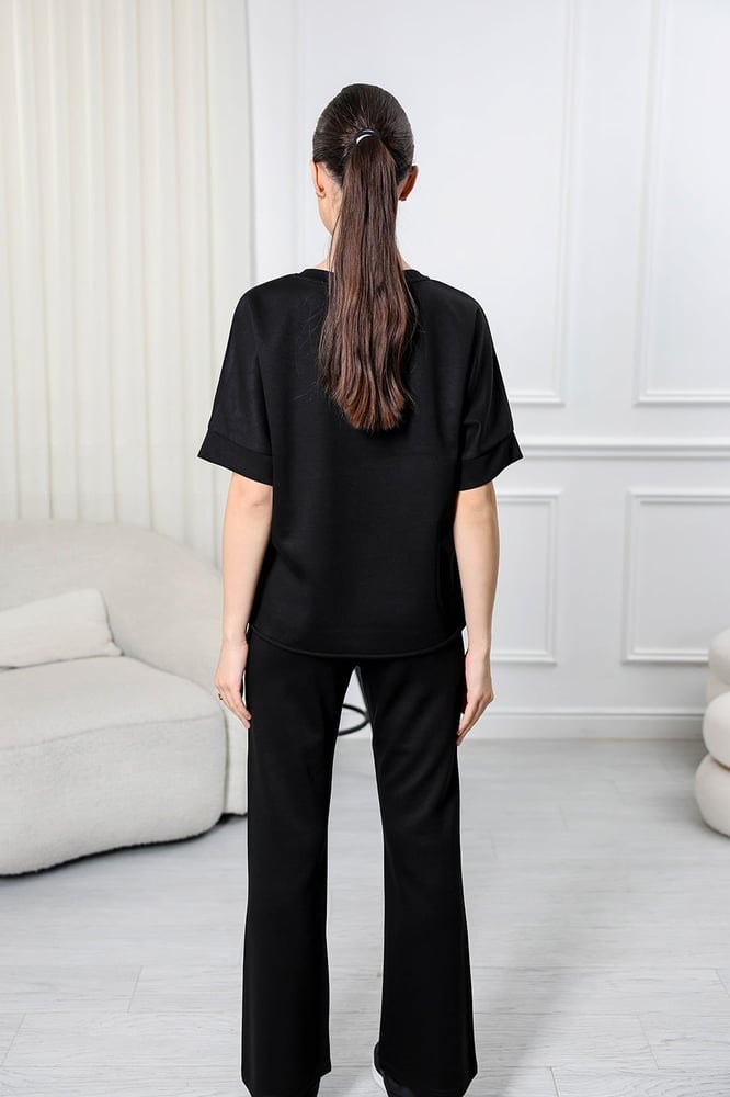 Women's casual tracksuit: T-shirt with elbow-length sleeves featuring a large print on the chest in gray, and pants with a wide, gathered waist.