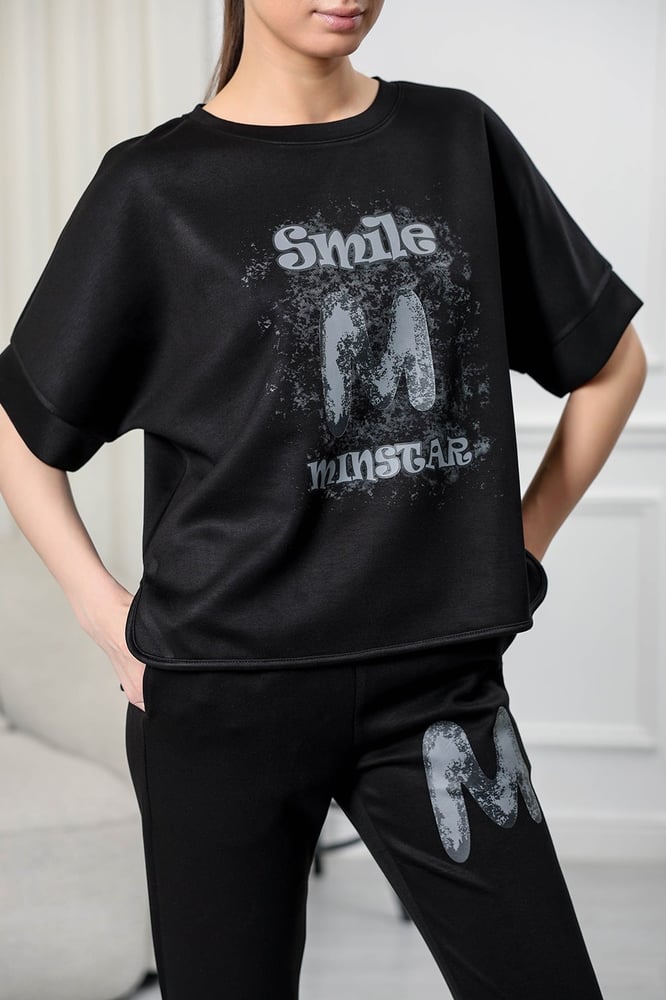 Women's casual tracksuit: T-shirt with elbow-length sleeves featuring a large print on the chest in gray, and pants with a wide, gathered waist.