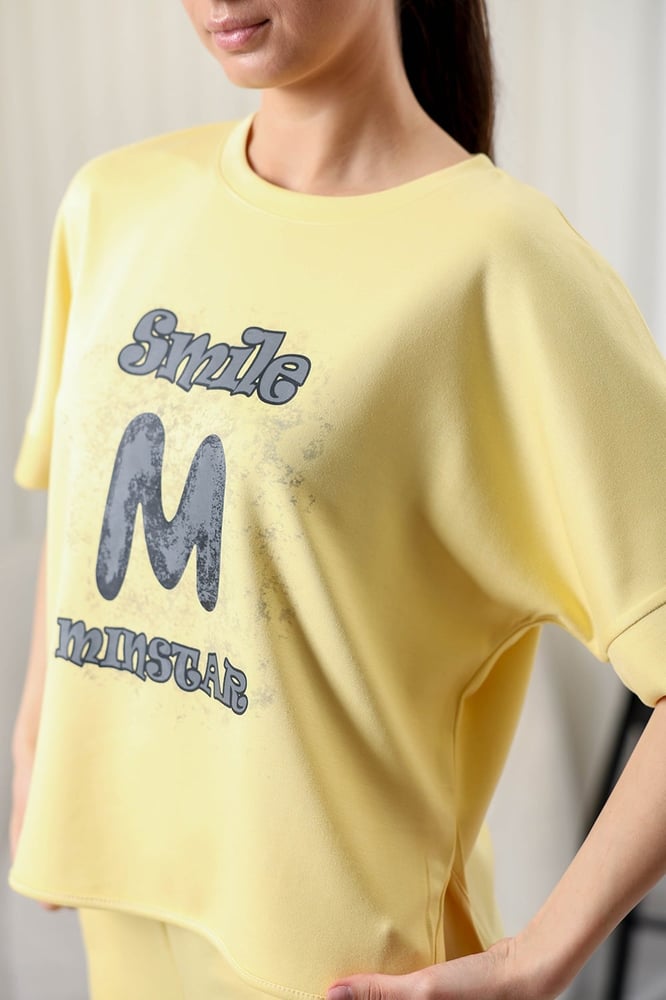 Women's casual tracksuit: T-shirt with elbow-length sleeves featuring a large print on the chest in gray, and pants with a wide, gathered waist.