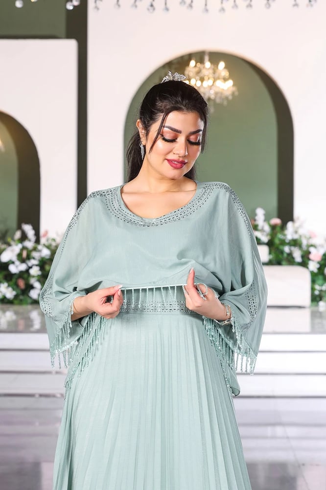 فستان سهرة ياقة مدورة وأكمام مزينة بالترتر بنهايات مزينة بشباشيل وتنورة بكسرات