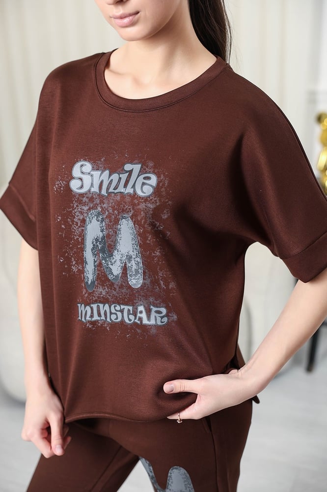 Women's casual tracksuit: T-shirt with elbow-length sleeves featuring a large print on the chest in gray, and pants with a wide, gathered waist.