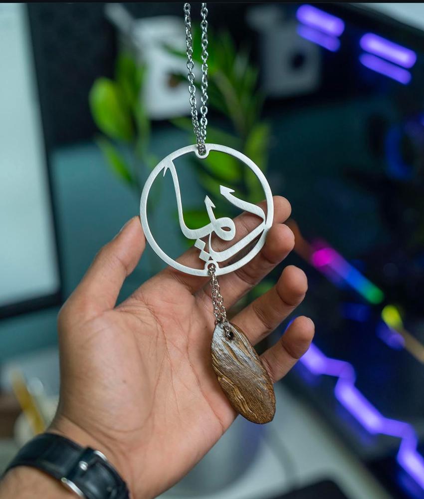 A pendant with the name and a piece of oud