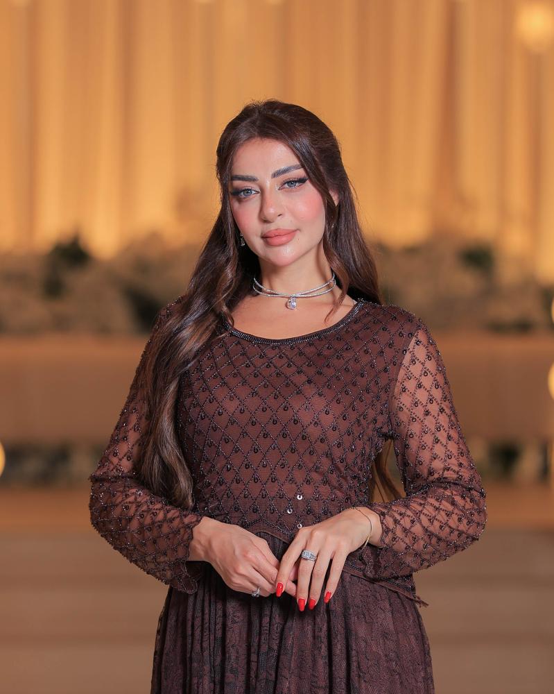 تفاصيل تطريز شبكي بالخرز والترتر على فستان بني طويل