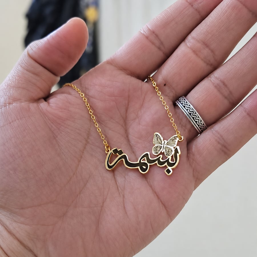 حلقي بجمال اسمكِ كالفراشة  سلسال مصمم بلمسات ذهبية او فضية دافئة ولون أسود ملكي يُبرز تفاصيل الاسم. صُمم خصيصاً بالاسم الذي تتمنينه ليكون بصمتكِ الخاصة أو لتهديه لمن تحبين.