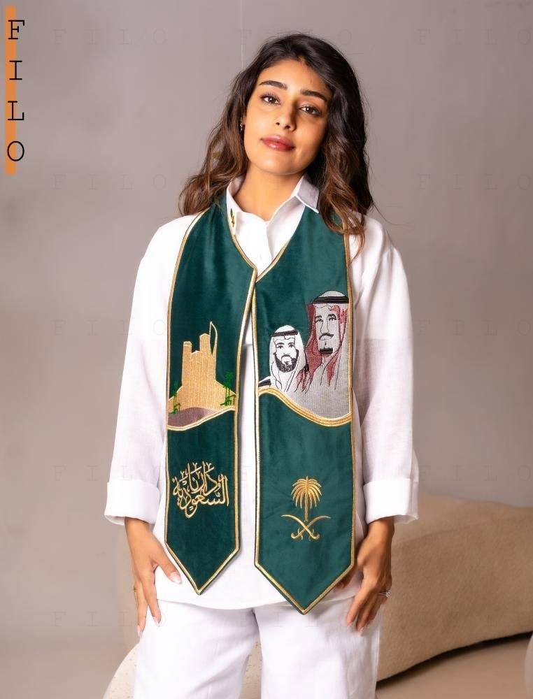 وشاح اليوم الوطني الأخضر على إطلالة نسائية بيضاء
