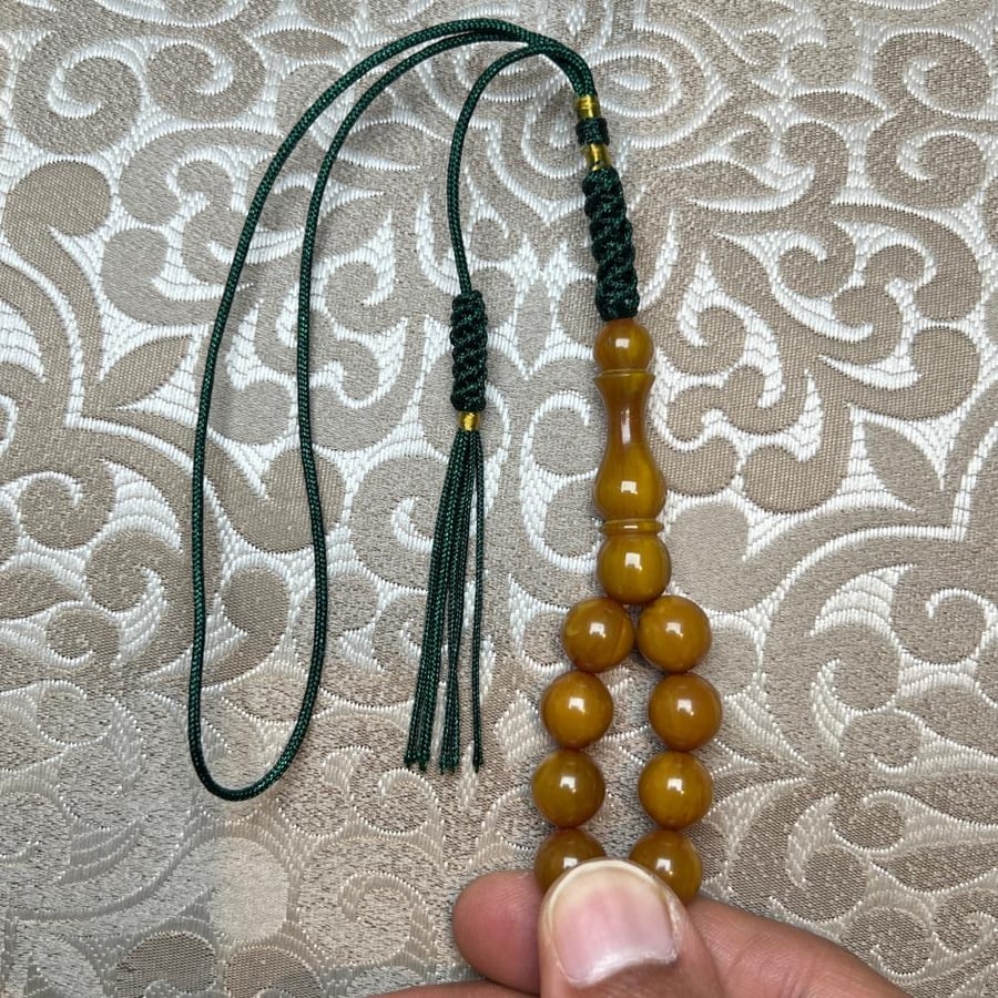 سبحة مستكة كروي بلون كهرماني مع خيط وشرابة خضراء