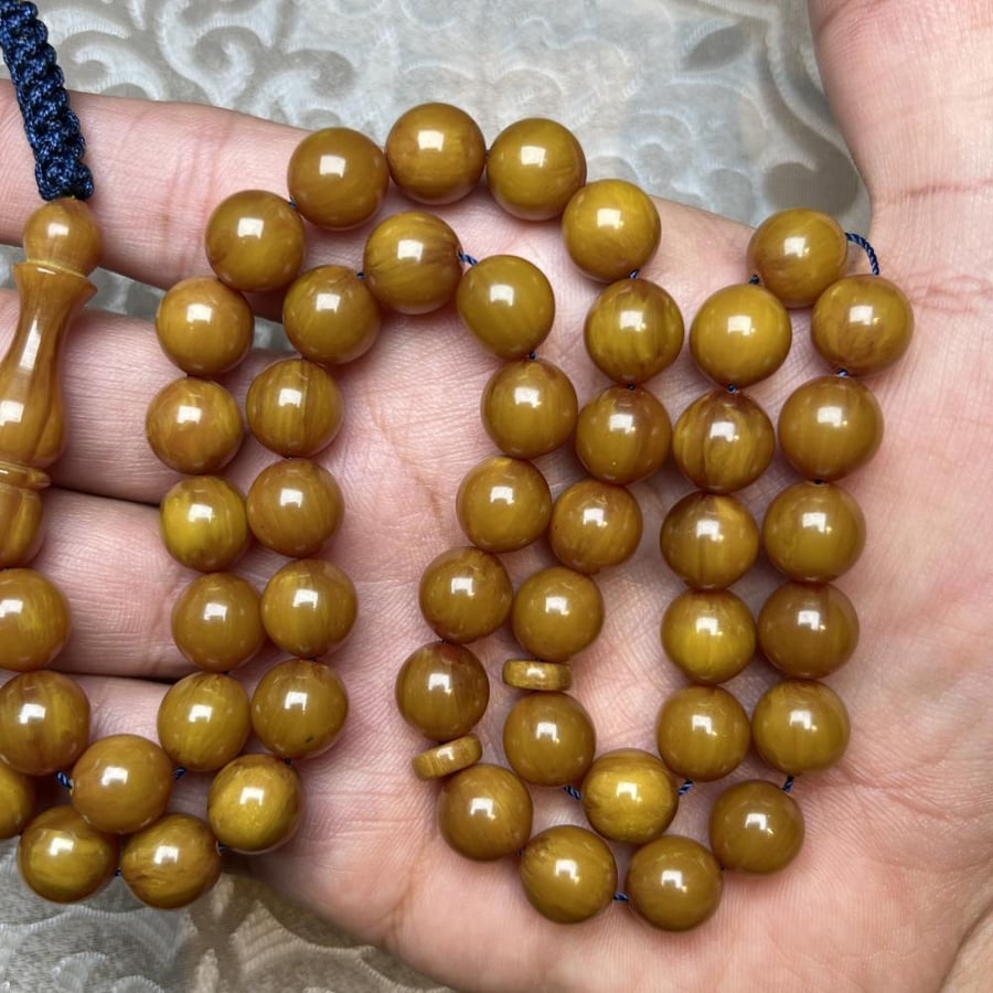 سبحة مستكة كروي بخرز كهرماني لامع وحبل أزرق