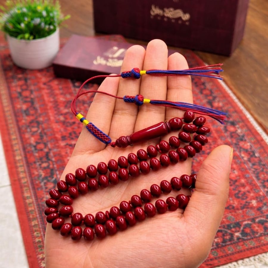 A prayer bead with a clasp with a tassel with a small pendant
