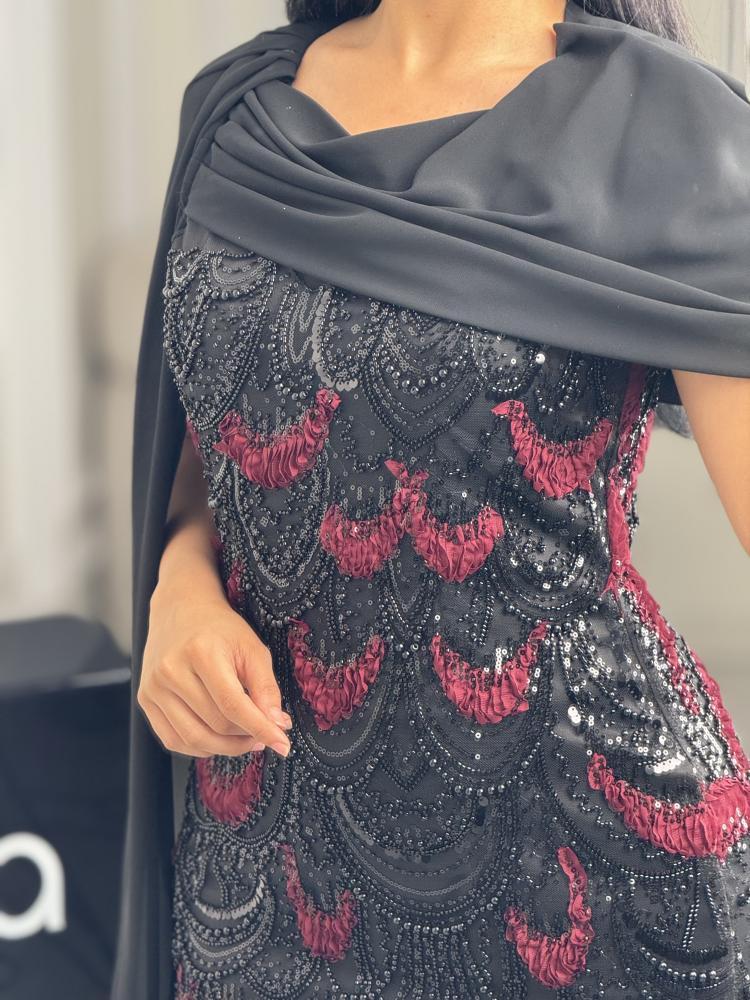 فستان سهرة أسود وأحمر مطرّز بكاب منسدل