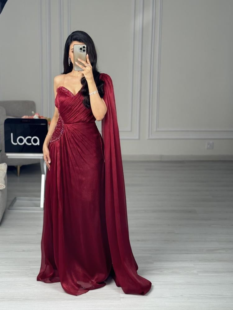 فستان سهرة خمري بكتف واحد وكاب منسدل
