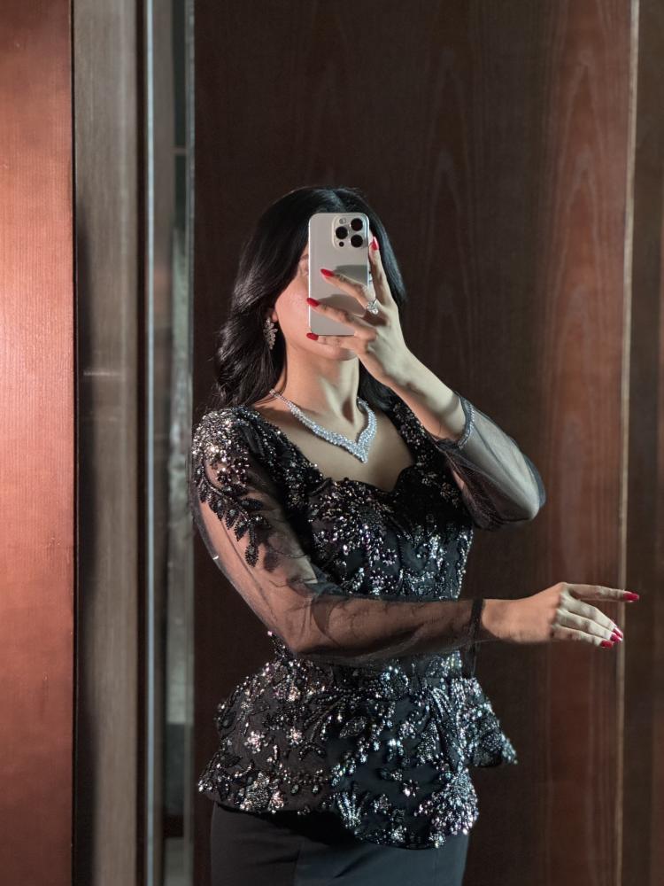 فستان أسود مطرّز ببيبلوم وأكمام شفافة وقصة ميرميد