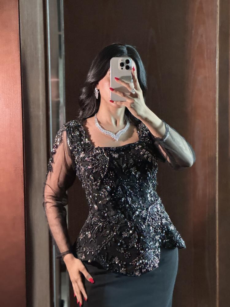 فستان أسود مطرّز ببيبلوم وأكمام شفافة وقصة ميرميد