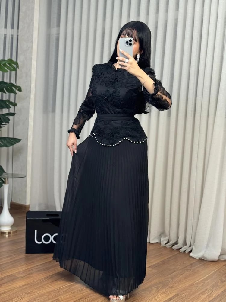 طقم أسود ببلوزة دانتيل وتنورة بليسيه