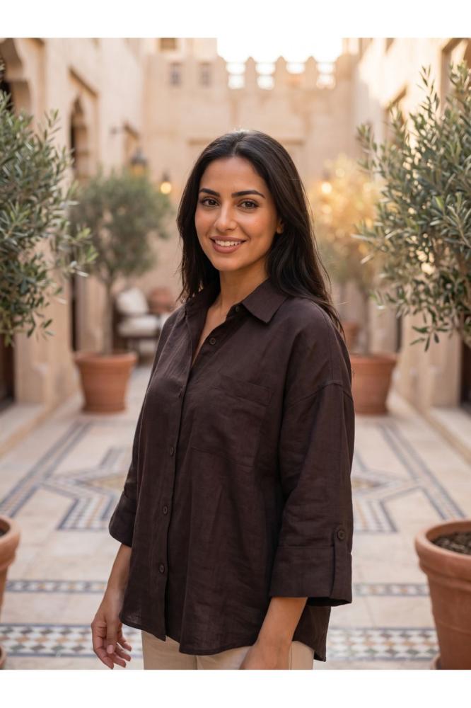 امرأة ترتدي قميصا نسائيا كتانيا بني اللون بأزرار أمامية وأكمام طويلة
