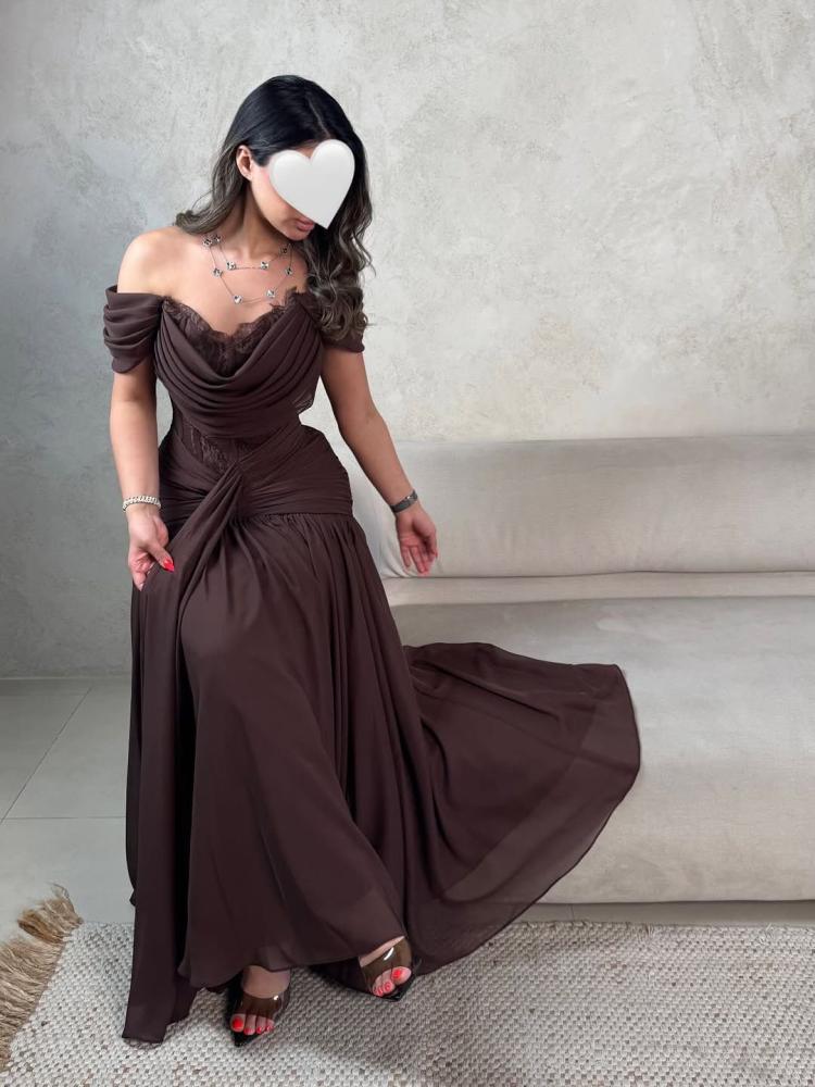 A luxurious brown dress with off-shoulder and flowing feminine pleats