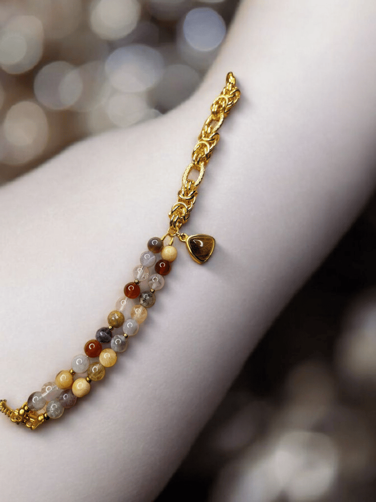 Elegant plated bracelet from a collection of natural stones that enhance mental calmness, amethyst, peacock stone, moonstone, with agate decorated with charms of natural tiger's eye stone
