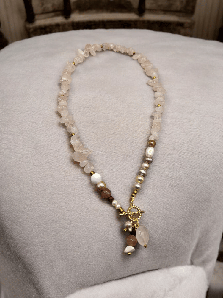A beautiful necklace of rose quartz and pearl, decorated with rubies and gold-plated clasps.