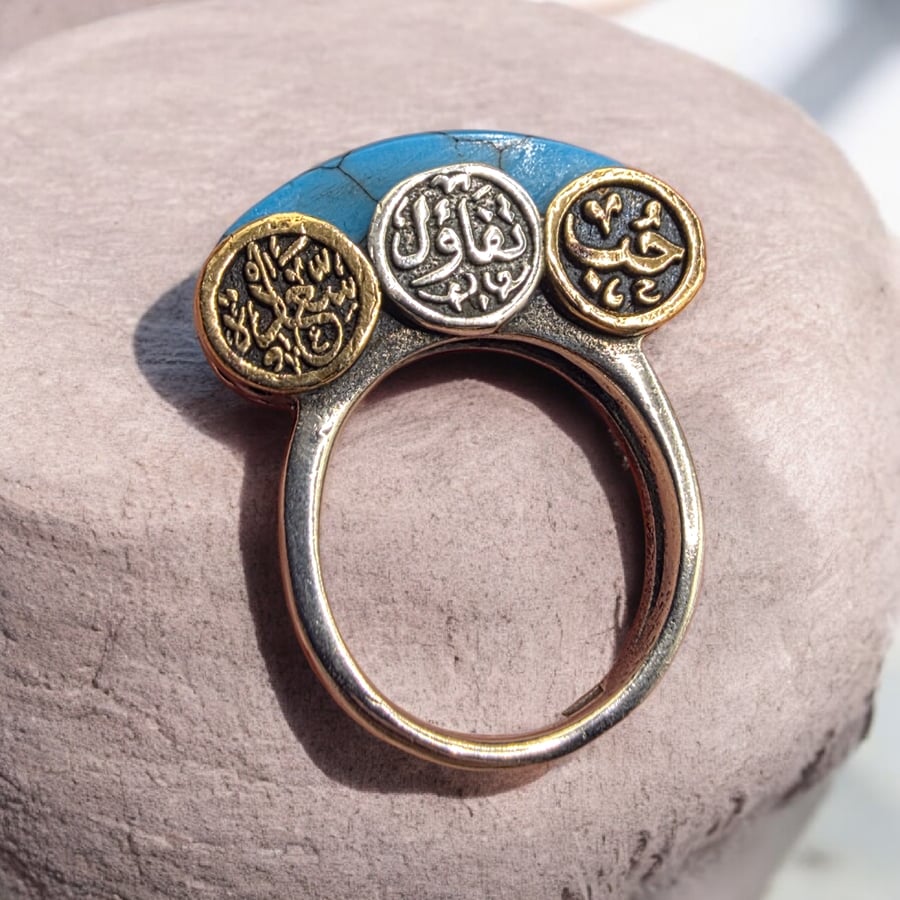 A distinctive and beautiful antique silver ring with turquoise, decorated with the words love, optimism, and happiness. Its owner bought it from Egypt years ago. Size 7
