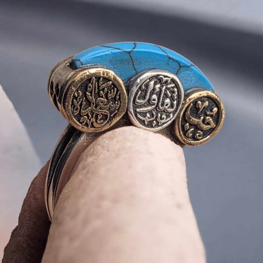 A distinctive and beautiful antique silver ring with turquoise, decorated with the words love, optimism, and happiness. Its owner bought it from Egypt years ago. Size 7