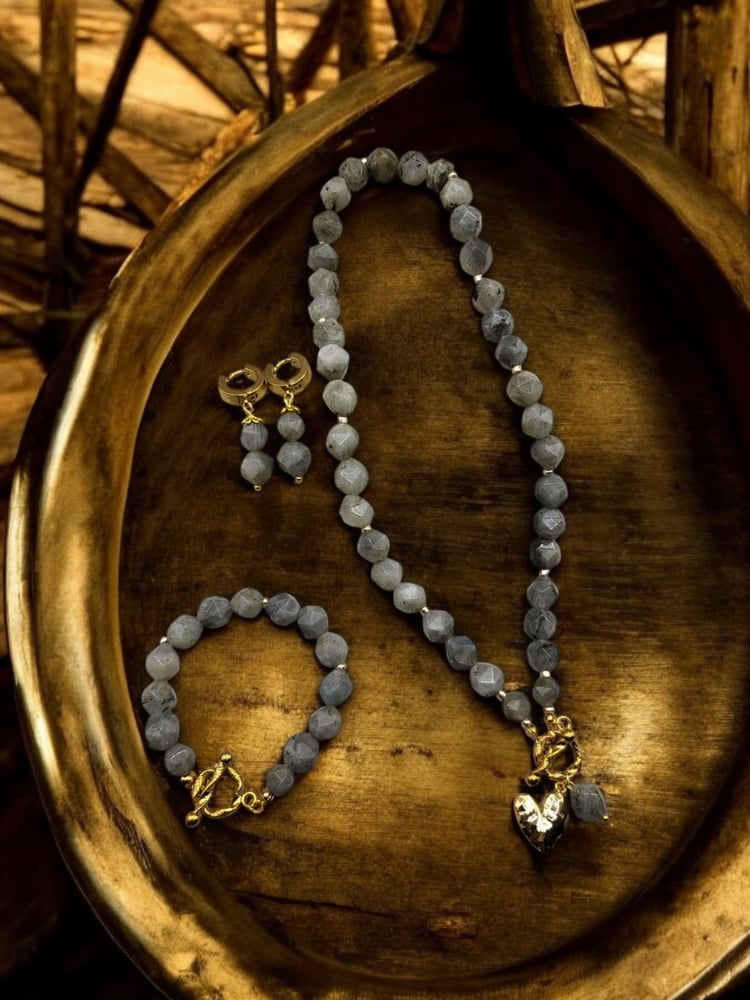 An elegant set of a necklace, bracelet, and earrings made of Labradorite with a hexagonal polish and clasps, with a gold-plated heart-shaped charm. It is also believed to improve focus, reduce anxiety and stress. It is considered a calming for the mind an