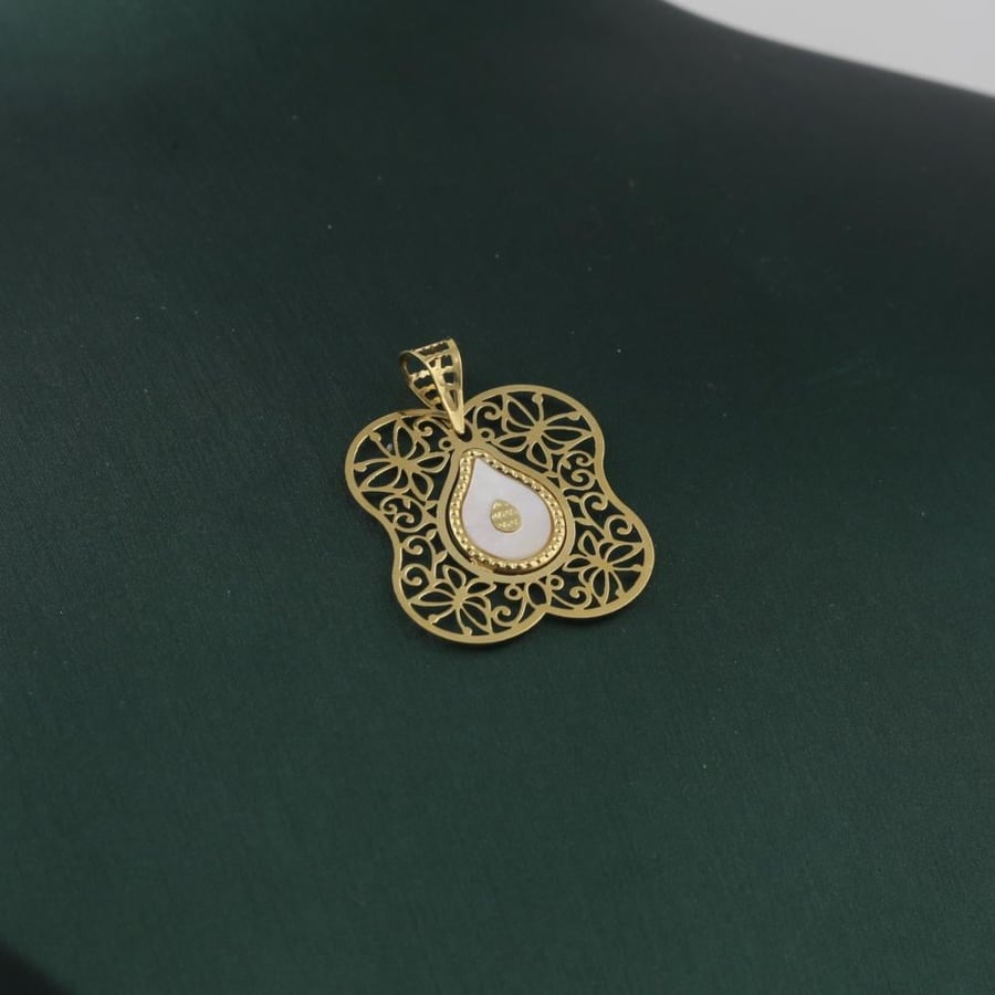 A distinctive gold pendant with a striking white tear - 18 karat
