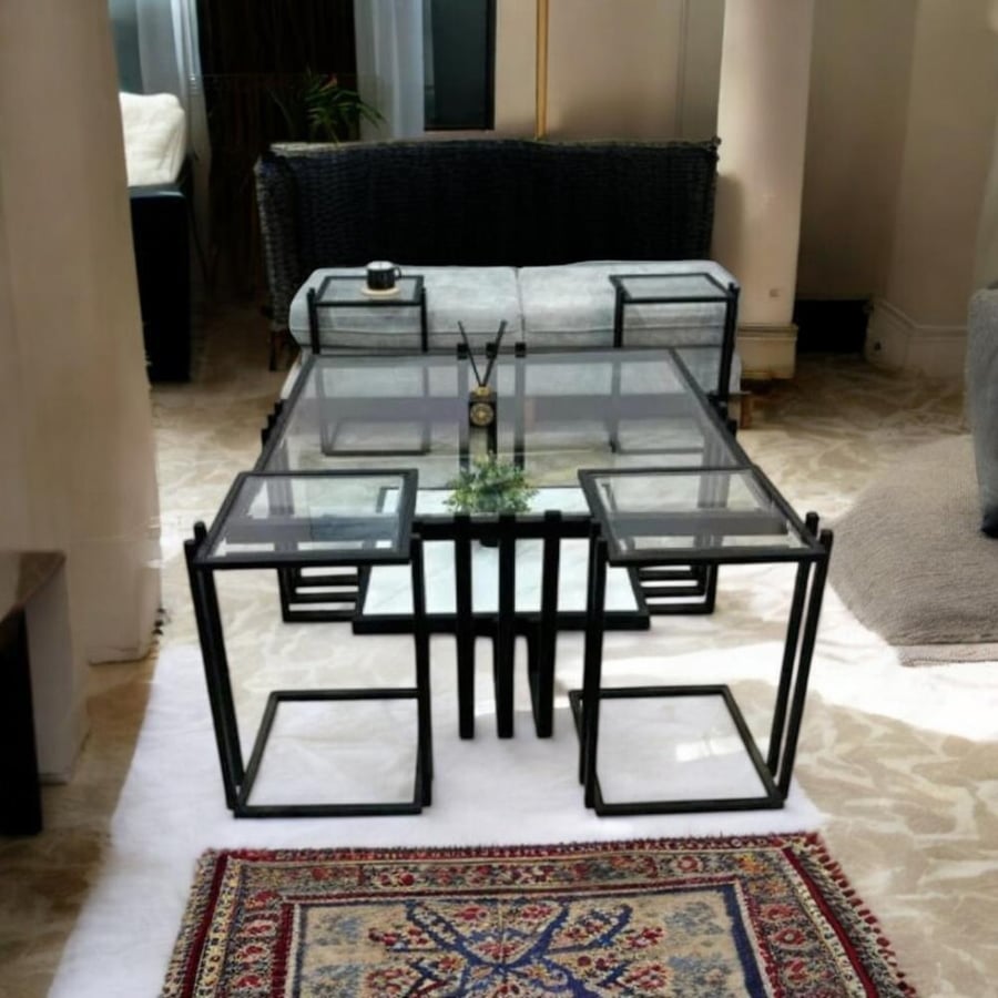 A set of coffee tables with transparent glass and a black iron frame