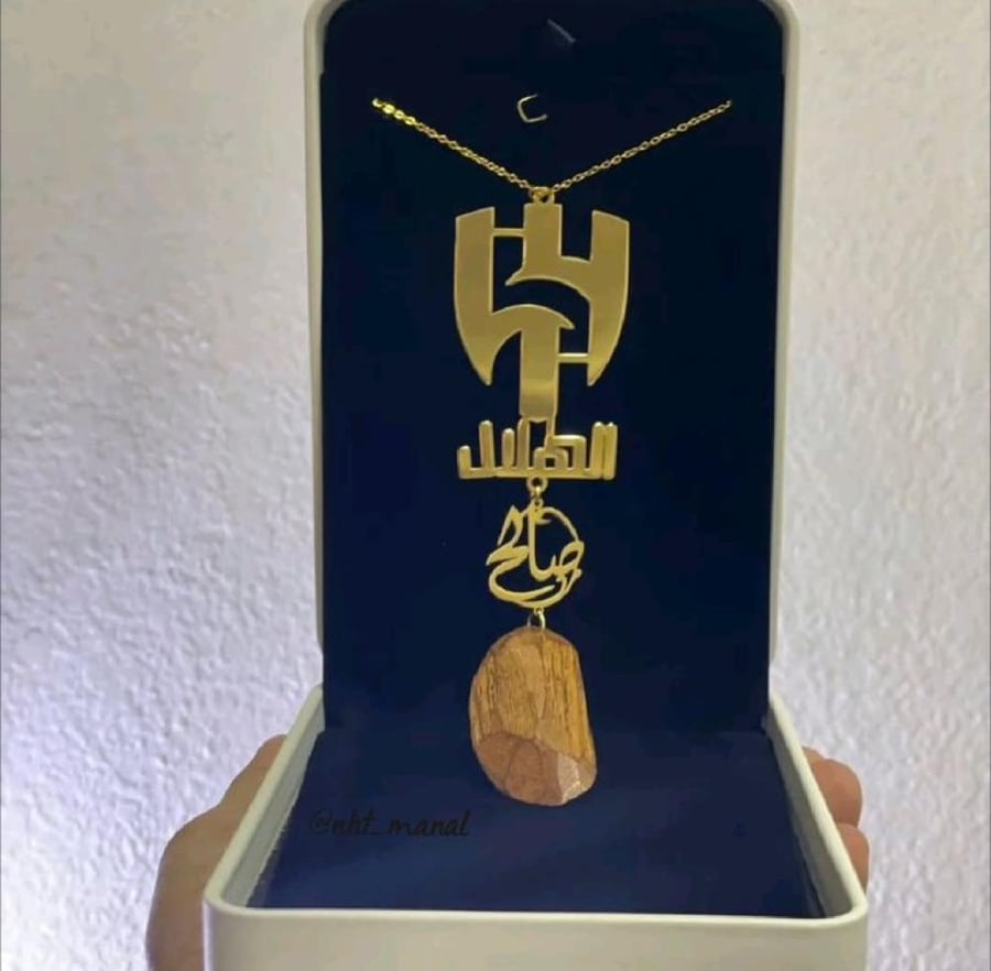 تعليقة سيارة بالاسم "فخر الزعيم"  بتصميم شعار نادي الهلال مع كسرة العود