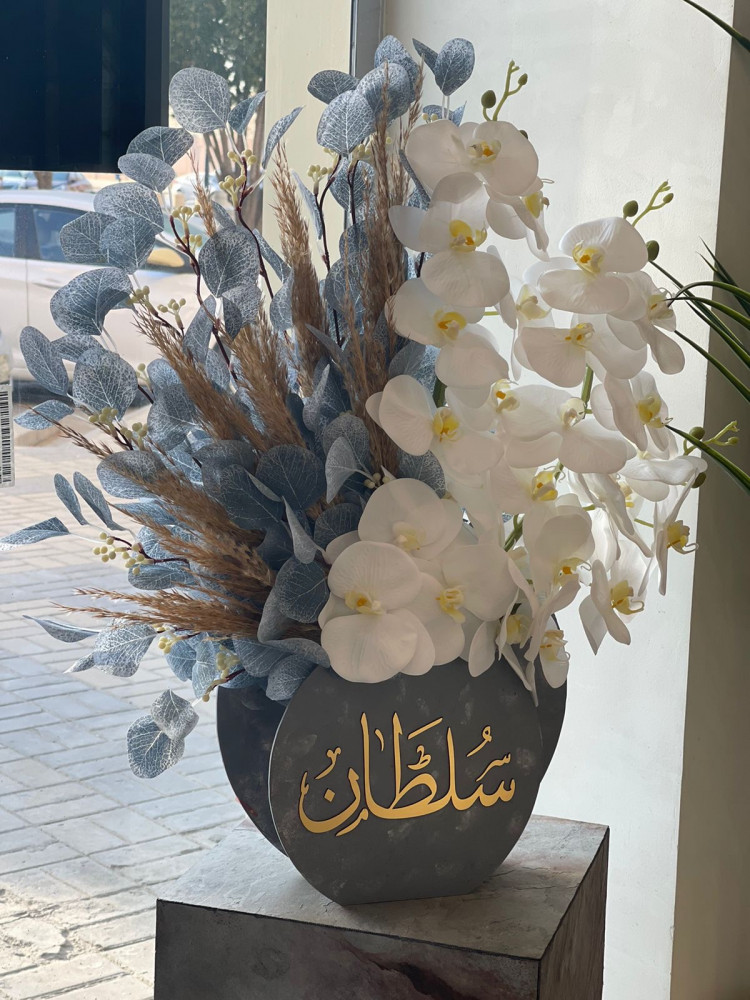 فازة ورد اوركيد مع اوراق الشجر