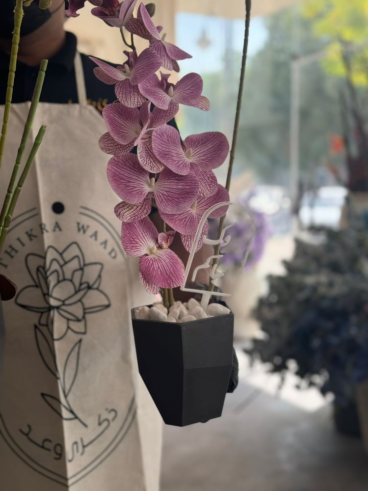 Vase of fiber with orchids