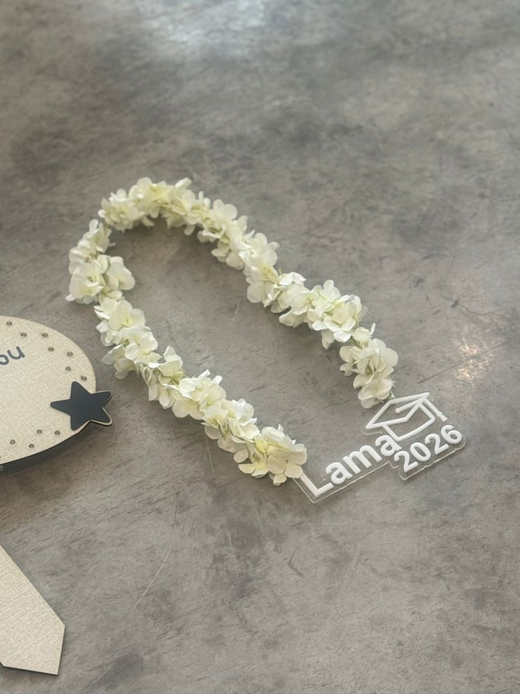 Graduation plaque with a graduation pendant, artificial flowers