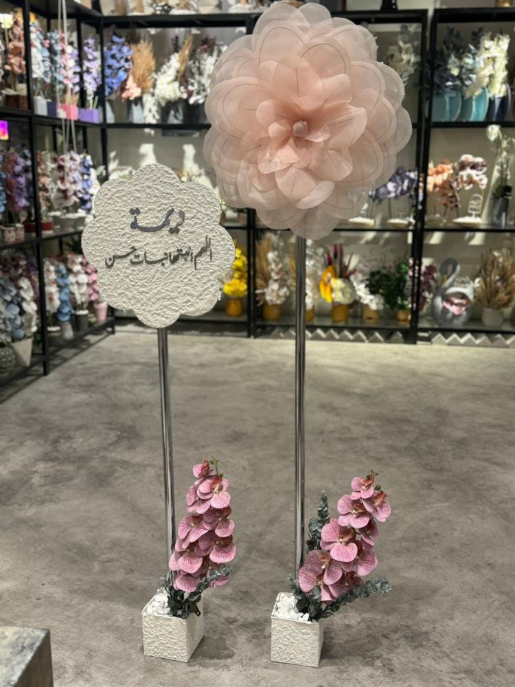 Event stand consisting of a flower vase with the name inscription and a flower vase with a fabric flower