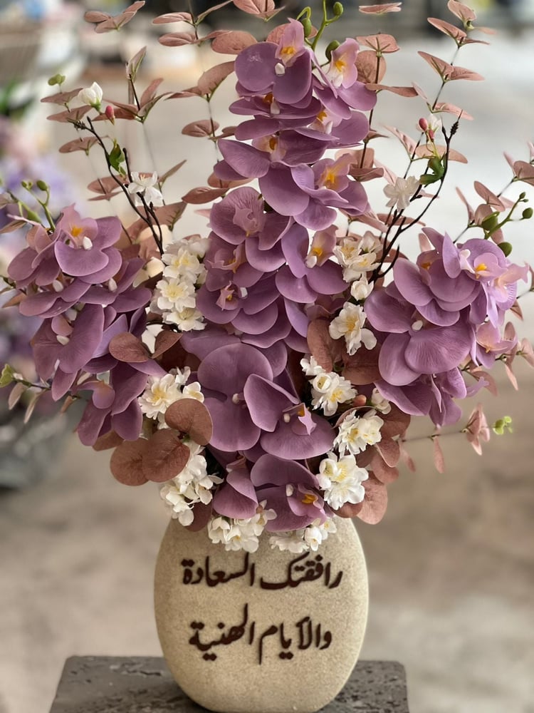 فازة حجرية مع ورد الاوركيد و الورد الصناعي