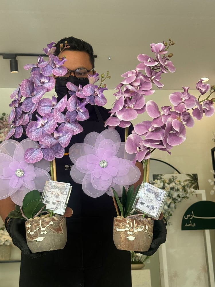 The cement vase with orchid flowers and fabric flower