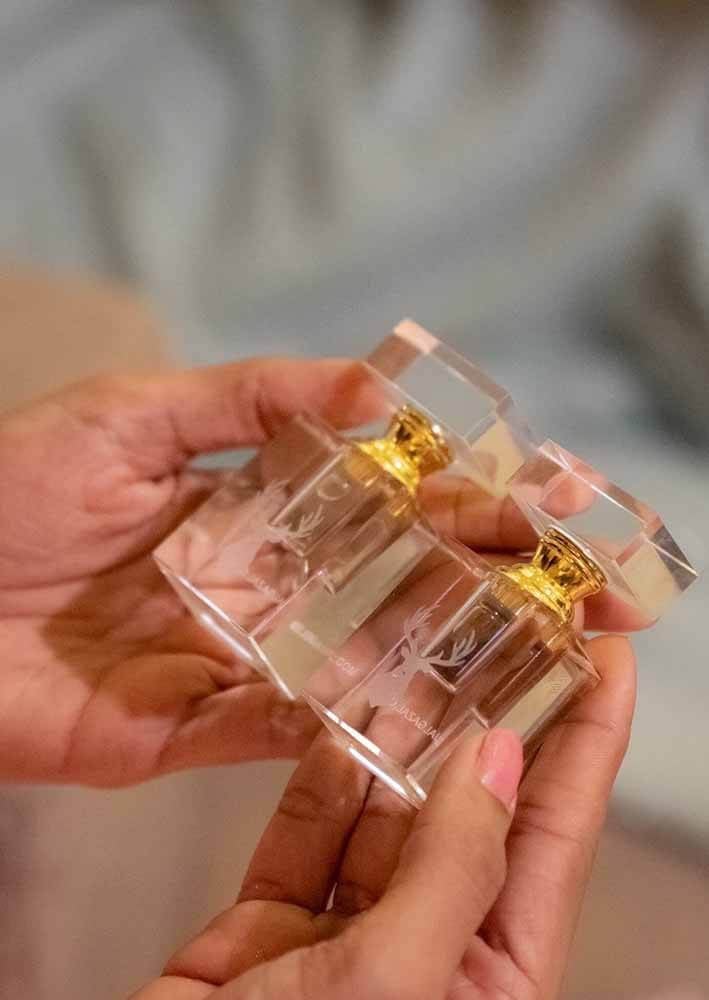 بنت تمسك بزجاجتين من دهن العود الصغير من متجر دهن عود عاج الغزال