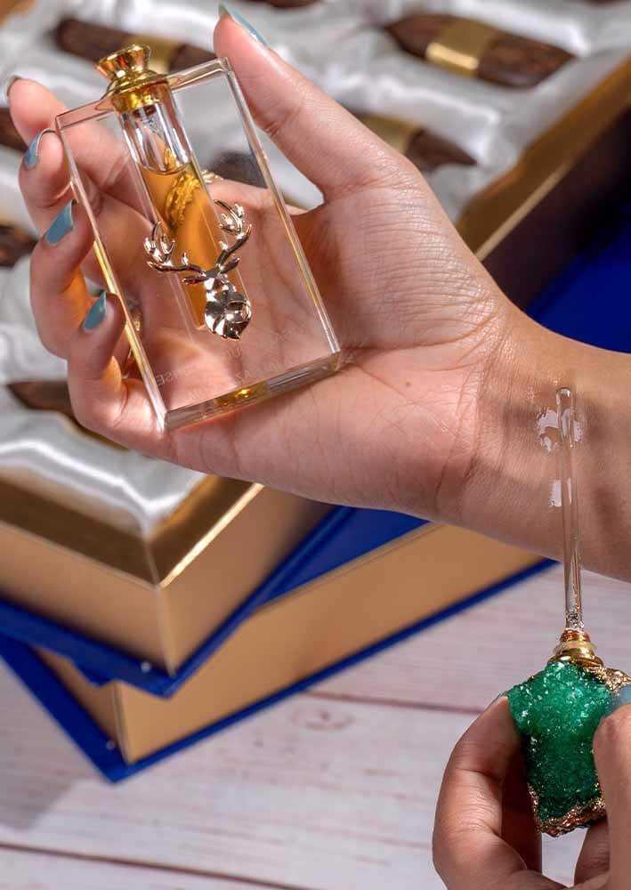 بنت في يدها دهن عود في متجر لون عاج الغزال
