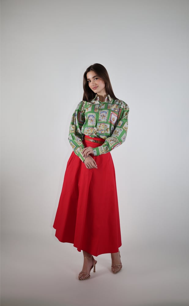 A distinguished two-piece set of a shirt with a unique pattern and a red skirt