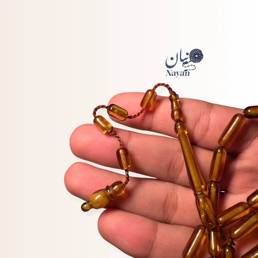 A beaded prayer necklace with soft blue, pine, caramel, and honey-colored beads.