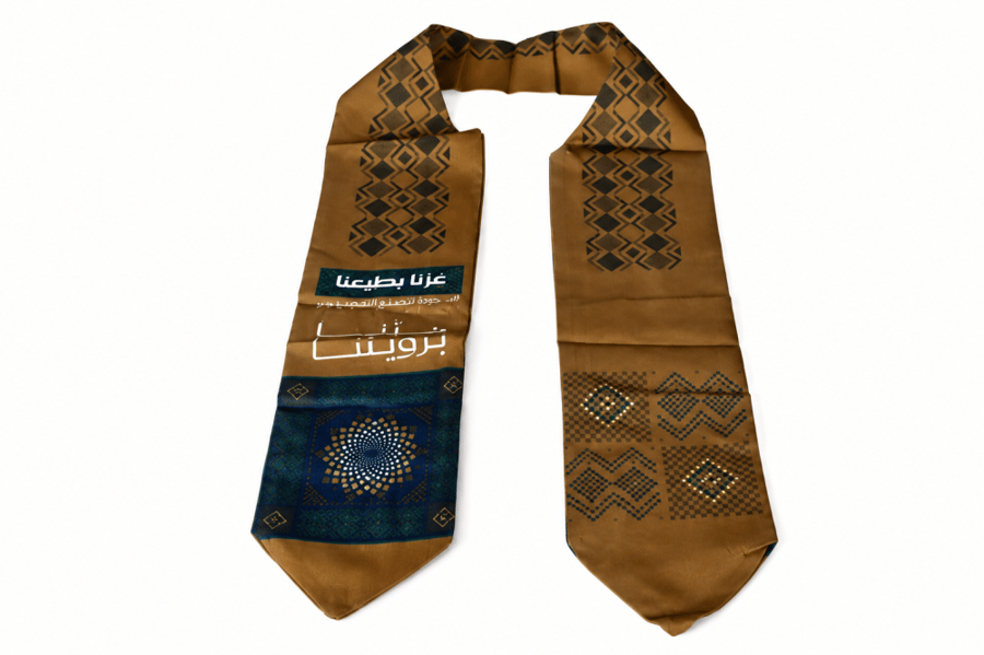شال اليوم الوطني السعودي قماش بلون بني وعبارة "عزنا برؤيتنا" مقاس 120×12 سم – شال احتفالي وطني أنيق، توزيعات وإكسسوارات مميزة لاحتفالات اليوم الوطني السعودي 96 والفعاليات الوطنية