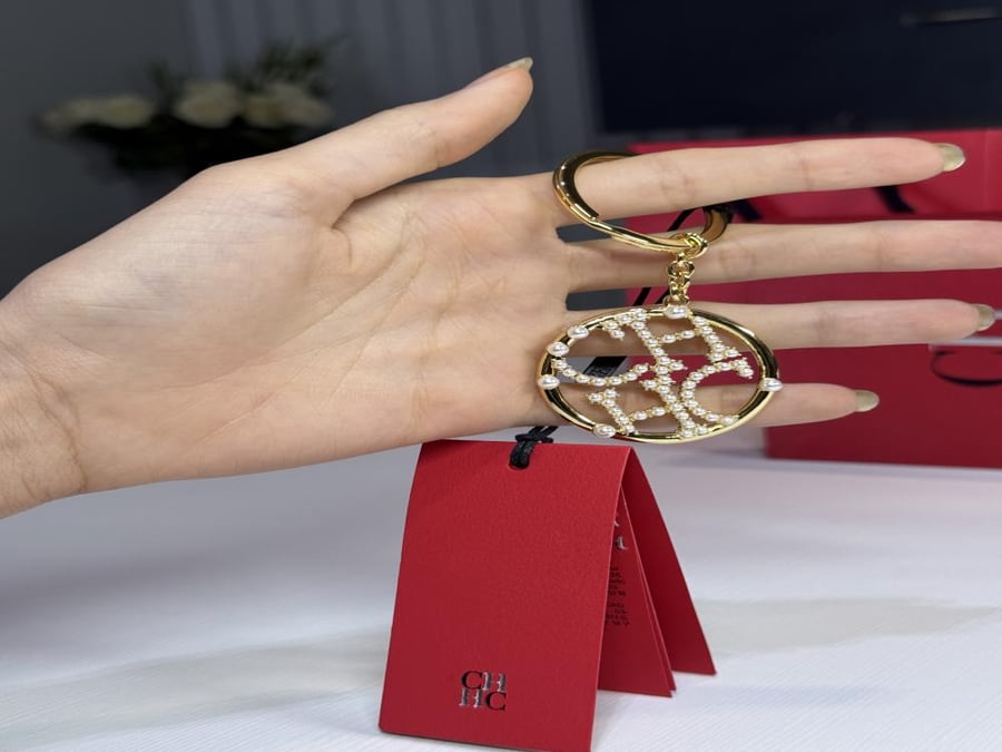 ميدالية كارولينا حلق لوقو باللون الذهبي مزين باللولو Carolina Herrera loop pearl keychain CH