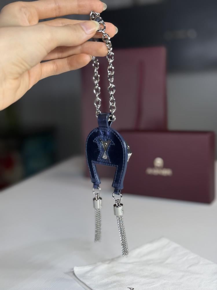 تعليقة اجنر باللون الازرق المعدني اللامع على شكل حذوه من الجلد الوردي Aigner metallic blue charm with stones and tassel's